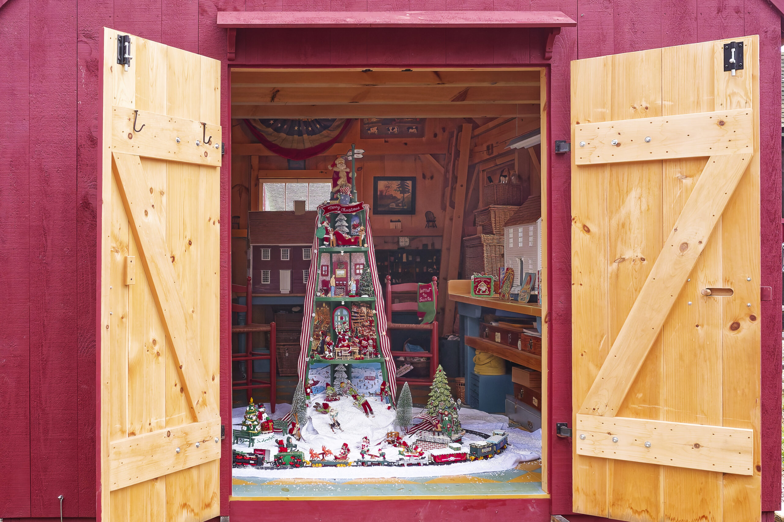 A dollhouse-themed Christmas tree inside of an Even Pitch Shed from Post and Beam Barns by Country Carpenters.