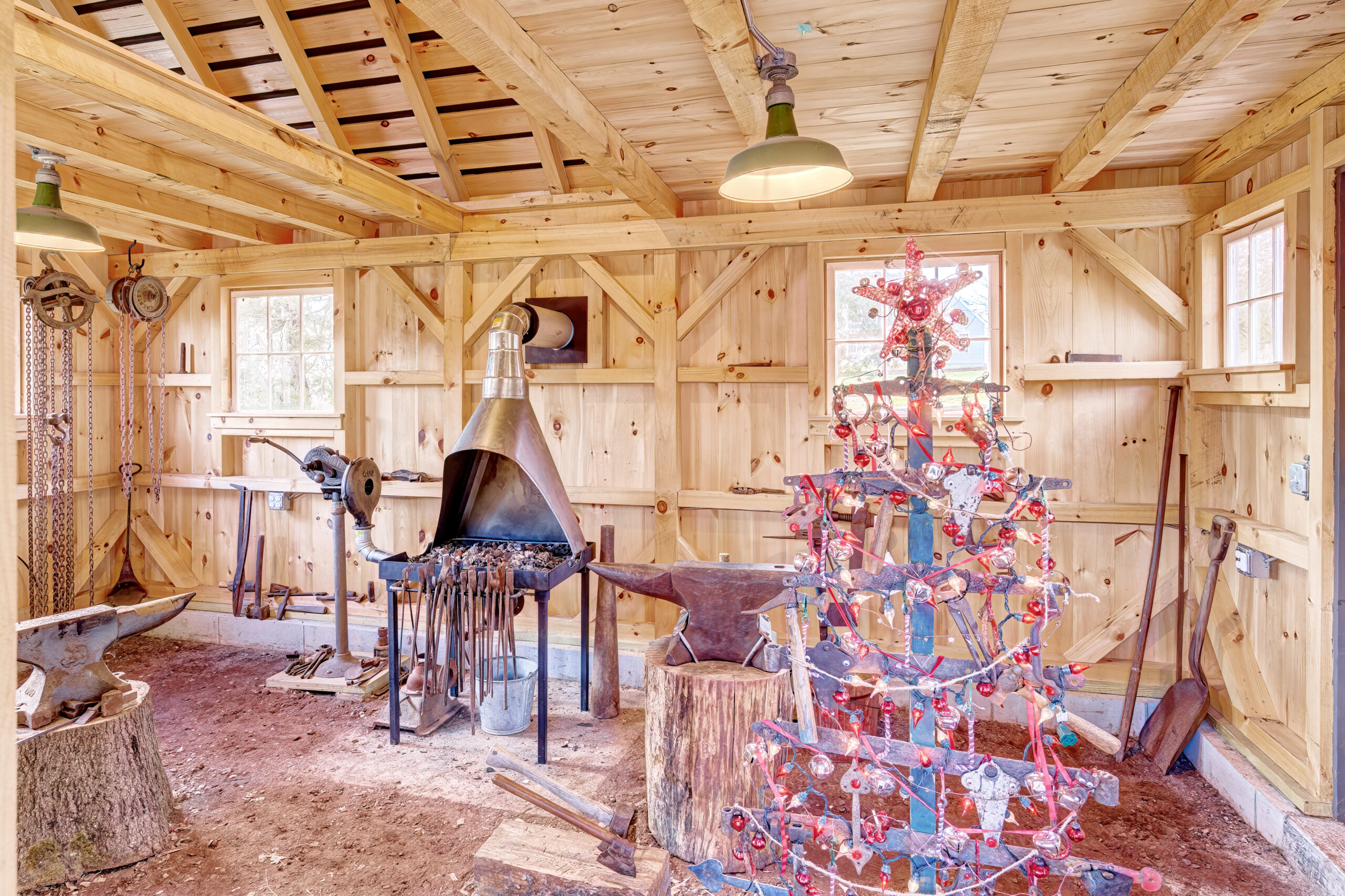 Interior of a Country Cabin from Post and Beam Barns by Country Carpenters. The cabin features a blacksmith-themed Christmas tree.